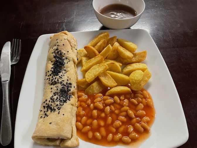 Filthy Vegan sausage roll with chips, beans and gravy