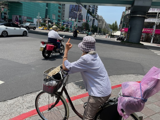 Old woman swearing while waiting to cross Zhongxiao E Rd